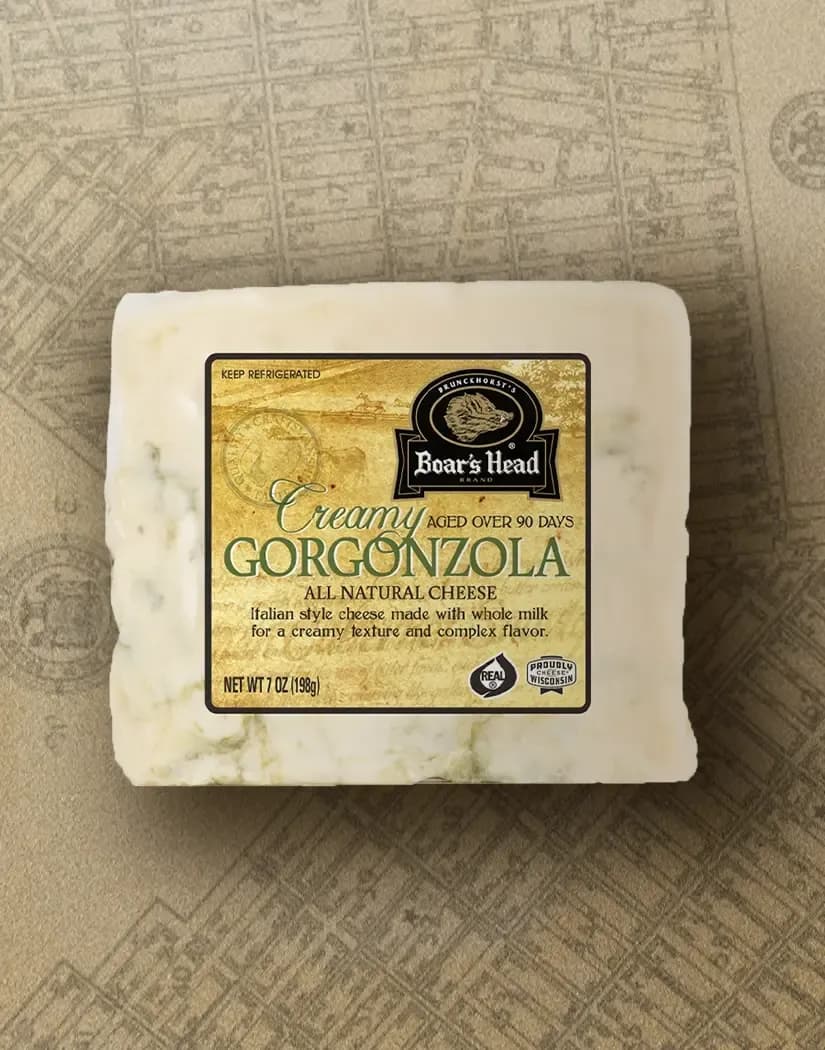The Boar's Head® Creamy Gorgonzola Cheese sits on a tan illustrated image of New York City.