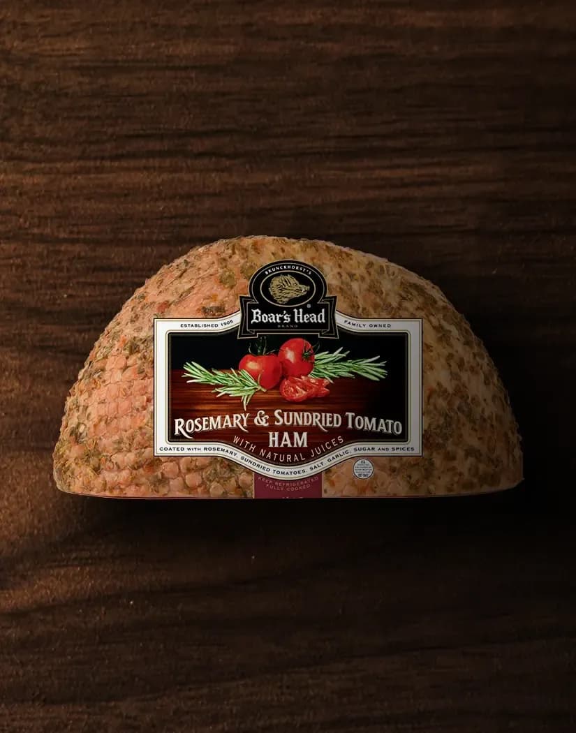 The Boar's Head® Rosemary & Sundried Tomato Ham sits on a wood background.
